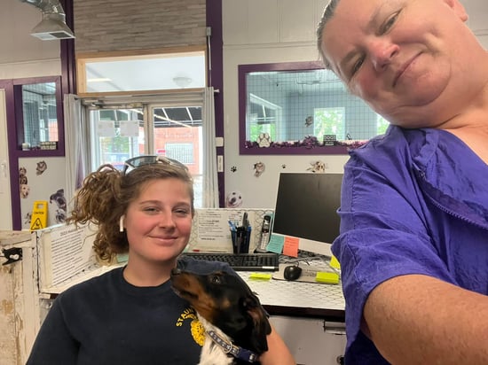 Jennifer, staff, and pup client at front desk of Clippin House