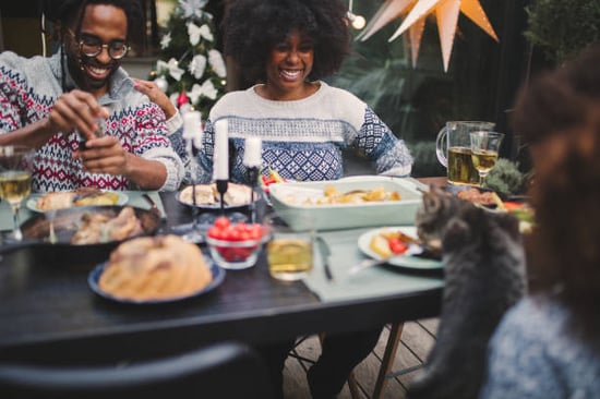 pet parents and cat sharing a festive feast