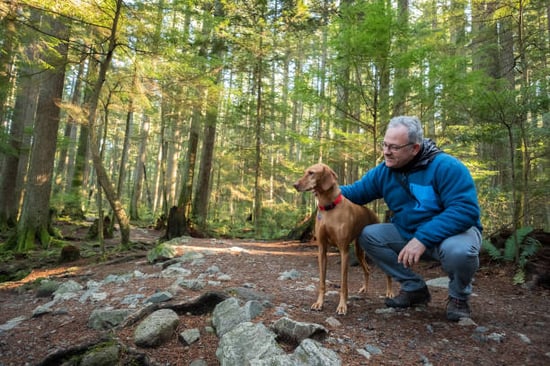 A person walks with a dog outside