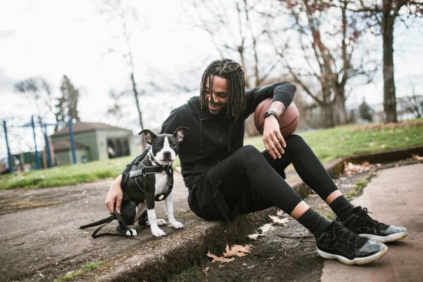 pet parent happily hanging out with his dog and basketball