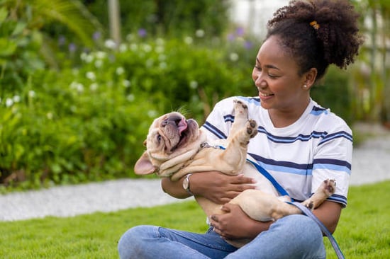 A woman holds her dog outside