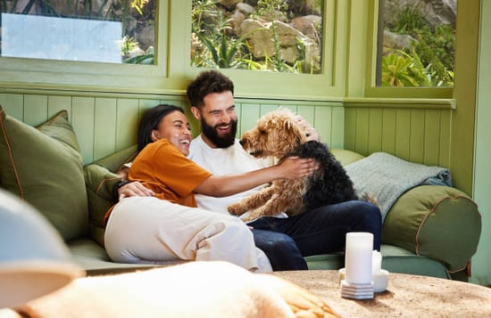 couple laughing with dog at home