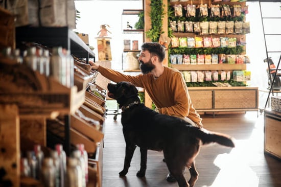 A person shops with a dog in a pet retail store