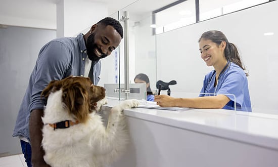 pet parent, groomer, and dog at front desk