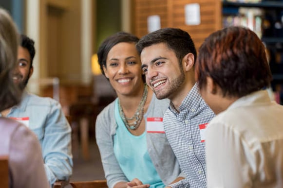 A group of people wearing name tags sit together